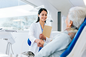  A dentist greeting an older patient in the chair