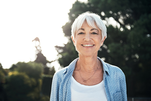 Older woman wearing a blue shirt shows a calm smile